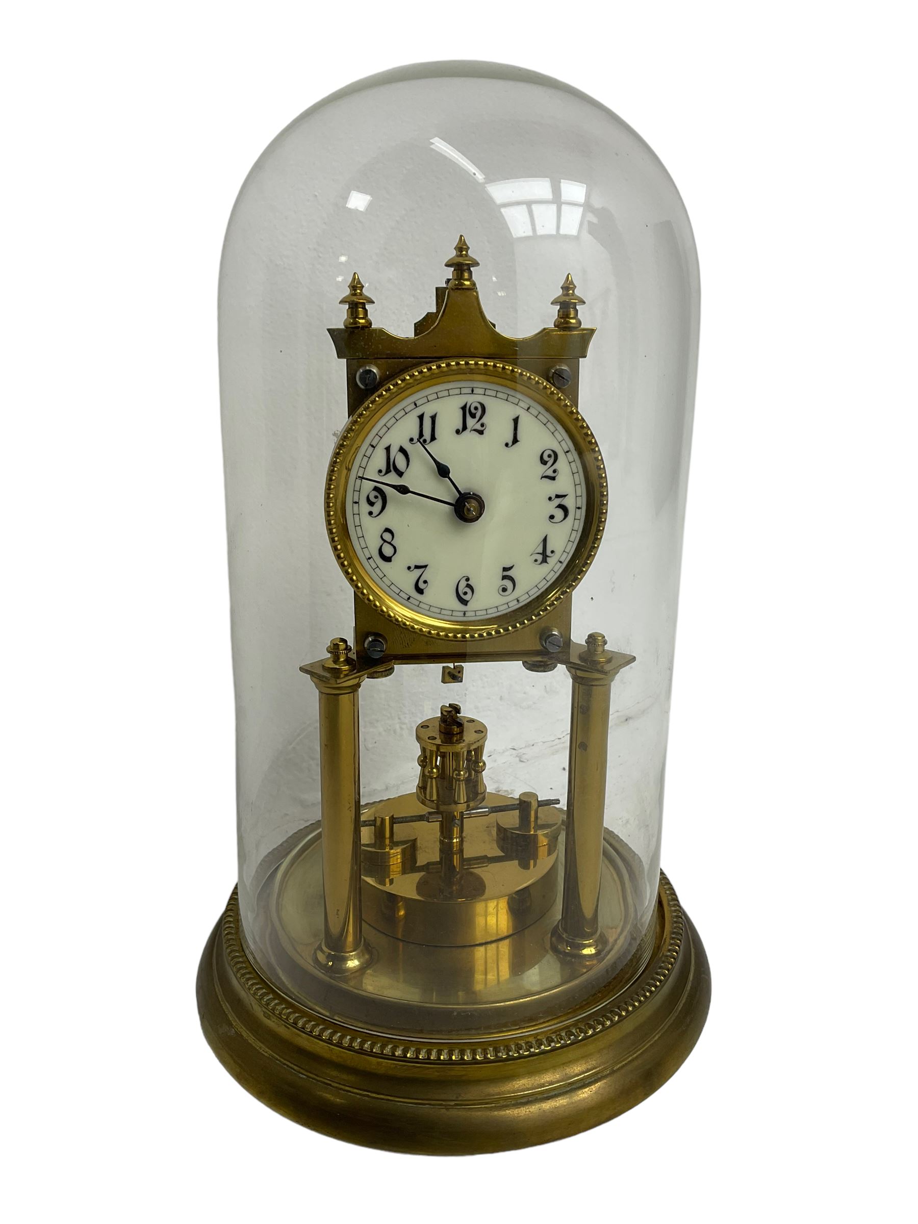 Gustav Becker - German Urania torsion clock with a glass dome, late 19th century 400-day movement with an enamel dial, arabic numerals and steel spade hands, movement supported by two brass pillars on a circular base, adjustable rotating pendulum with torsion suspension intact. With Key.