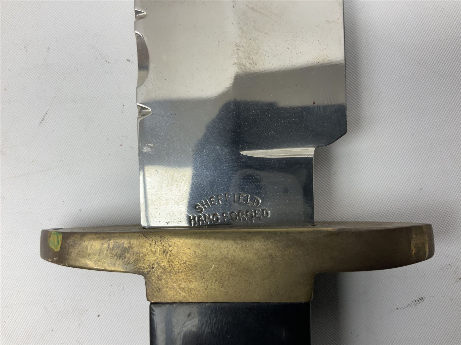 Large Bowie knife the 21cm steel blade marked J.E. Middleton & Sons Rockingham Street Sheffield with brass cross-piece and polished horn grip scales; in leather sheath L36cm overall