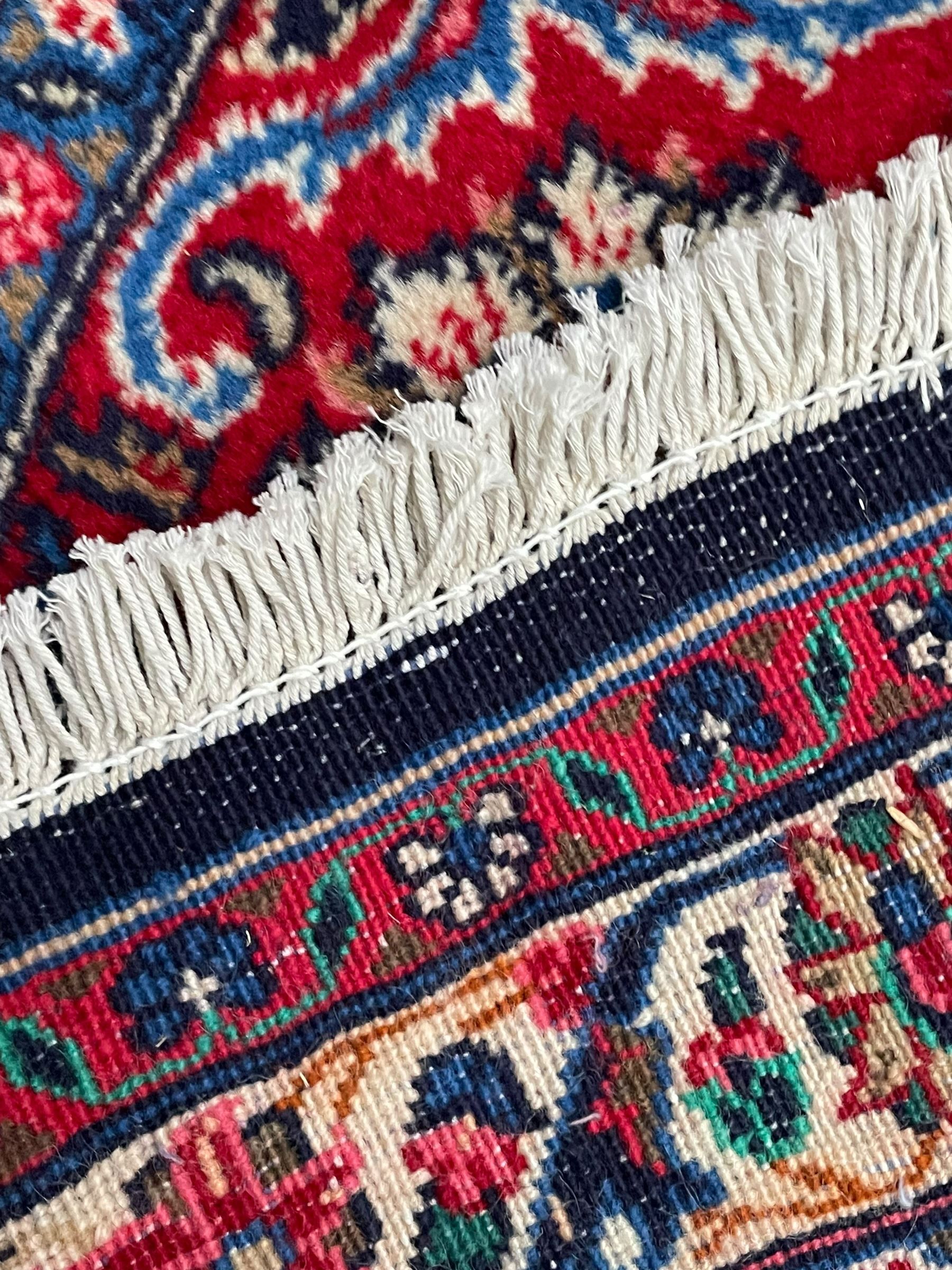 Persian Hamadan indigo ground carpet, the field decorated with central rectangle and outer band, overall floral pattern with cusped central medallion and surrounding leafy branches with palmettes, the border with scrolling branches decorated with further palmettes, within floral pattern guard stripes