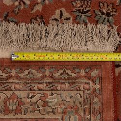 Persian vermillion ground Kashan rug, the busy field decorated with a central floral pole medallion, surrounded by trailing foliage and profusely woven floral patterns and bouquets, the dark indigo spandrels and multiple guard bands with similar floral decoration and stylised spandrels