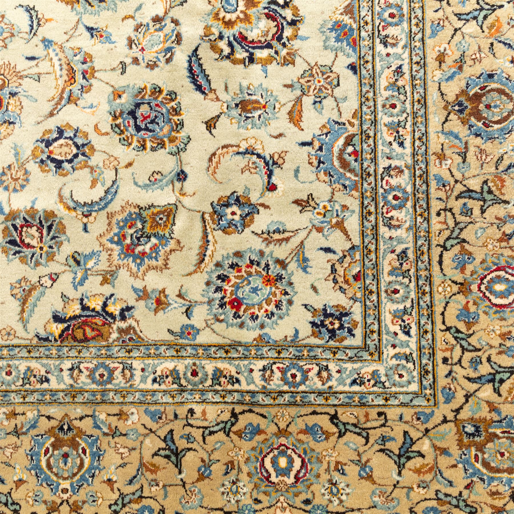 Central Persian Kashan hand-knotted carpet, cream ground with radiating floral rosette medallion in soft blue and terracotta, the field filled with stylised blooms, cloudband vines and palmette motifs, enclosed by triple borders featuring lotus and boteh designs, with cotton fringe ends 