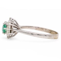 White gold emerald and diamond cluster ring, single oval cut emerald of approx 0.25 carat, surrounded by six round brilliant cut diamonds, stamped, total diamond weight approx 0.30 carat