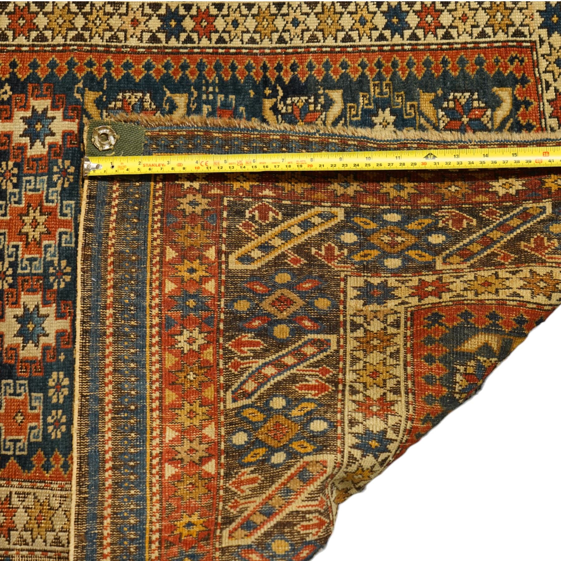 Two antique Caucasian Shirvan rugs, indigo field decorated with horizontal bands of small geometric floral and star motifs within multiple finely drawn borders featuring diamonds, rosettes, and stylized leaves in a palette of madder red, ivory, ochre, and pale blue, with fringe ends, 195x137cm, together with a similar smaller rug, 143x96cm