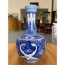 Late Qing Dynasty bottle vase decorated in blue and white with dragons and pearls, stylised leaves and flowers with key pattern foot H40cm 