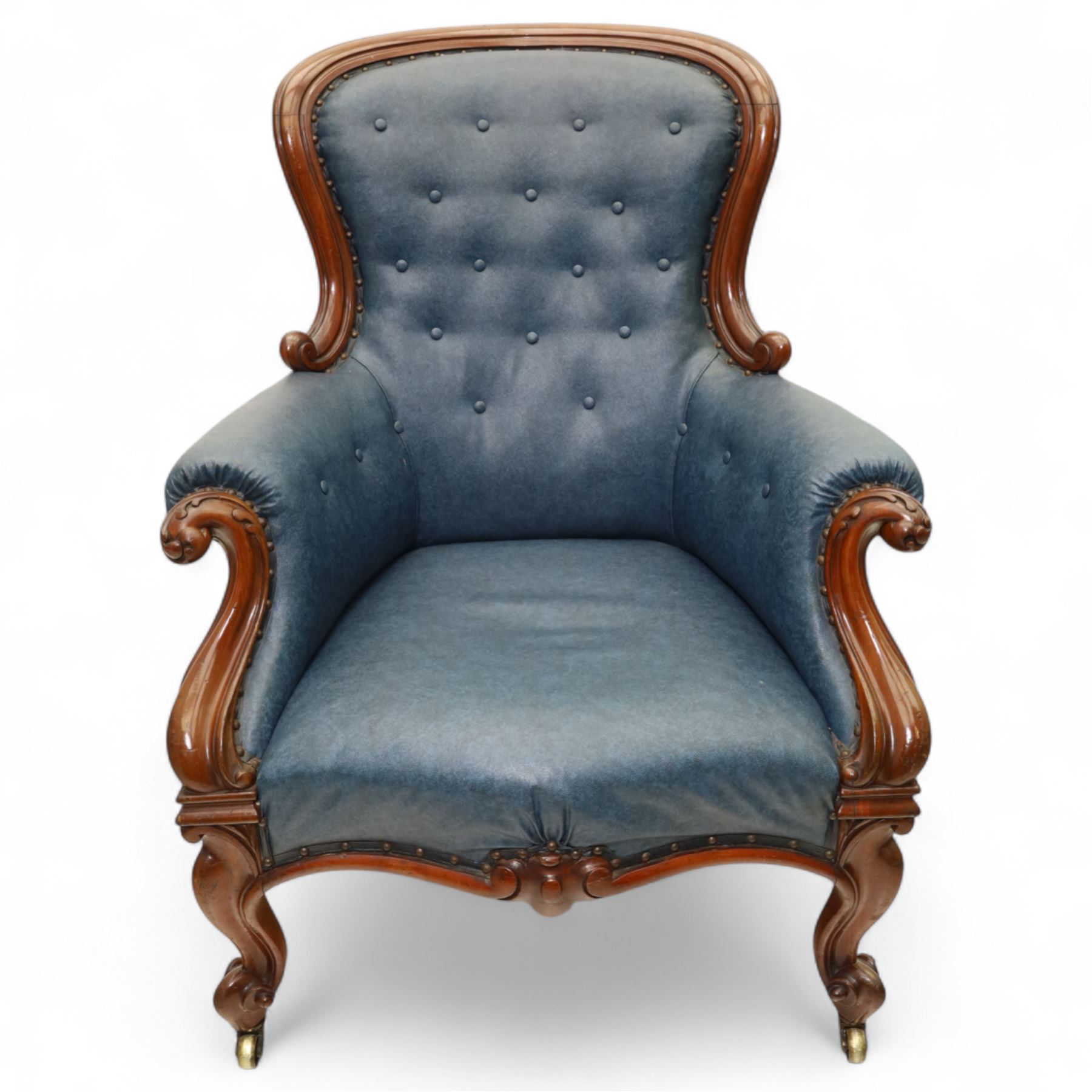 Fine pair of mid-19th-century mahogany library armchairs, carved frame with balloon-shaped back with scrolled ends, rolled wide arms, ending in a scrolled volute above a serpentine seat rail, upholstered in mottled turquoise faux leather, button upholstered back, arms, and cushion seat, studded sides and apron, raised on scroll carved front feet and splayed rear legs on castors 