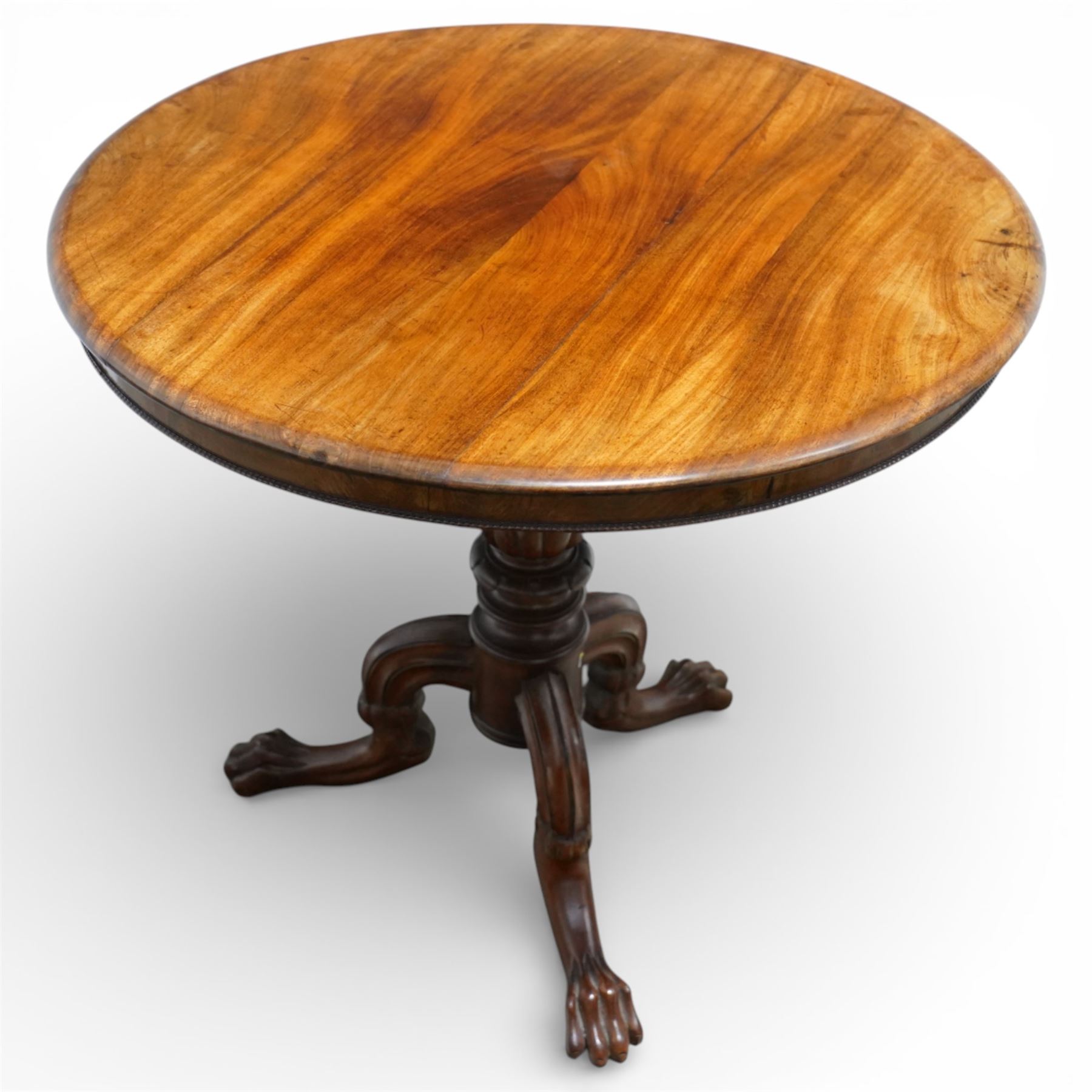 19th century mahogany centre table, with circular tilt top on a turned and reeded column, raised on three carved cabriole legs terminating in paw feet