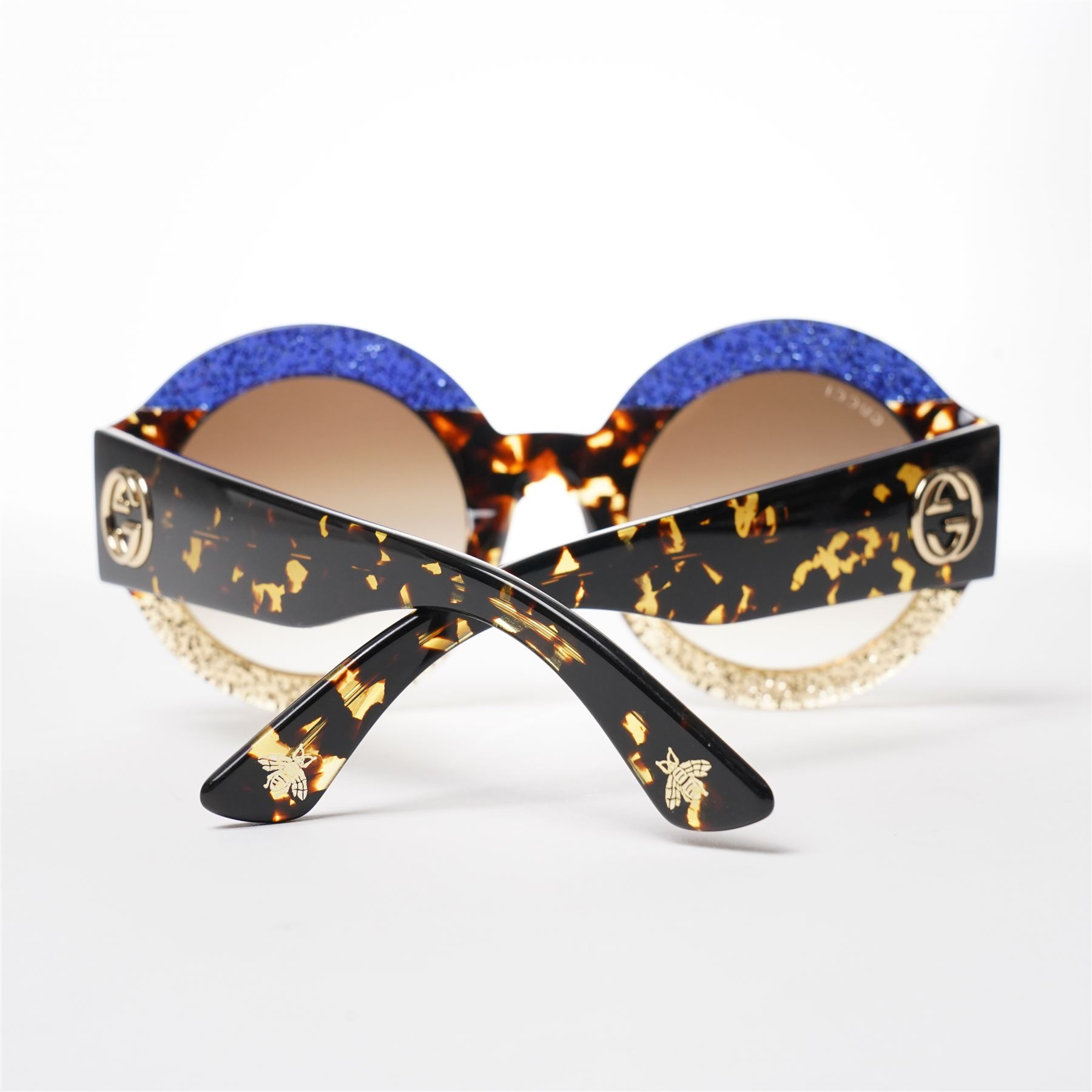 Gucci - pair of oversized round sunglasses, with gradient tinted lenses in a tortoiseshell-effect frame with blue and gold glitter inlay, the temples with interlocking gold-tone GG logo and bee motif, unused with original cloth and hard cases