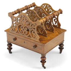 Victorian walnut Canterbury, scroll pierced divisions with turned carrying handles above a frieze drawer with knob handles, raised on turned legs terminating in brass castors