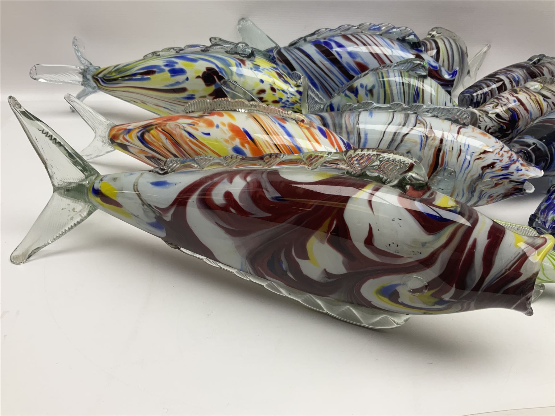 Collection of mid 20th century murano style glass fish, each with multi coloured inclusions largest L42cm