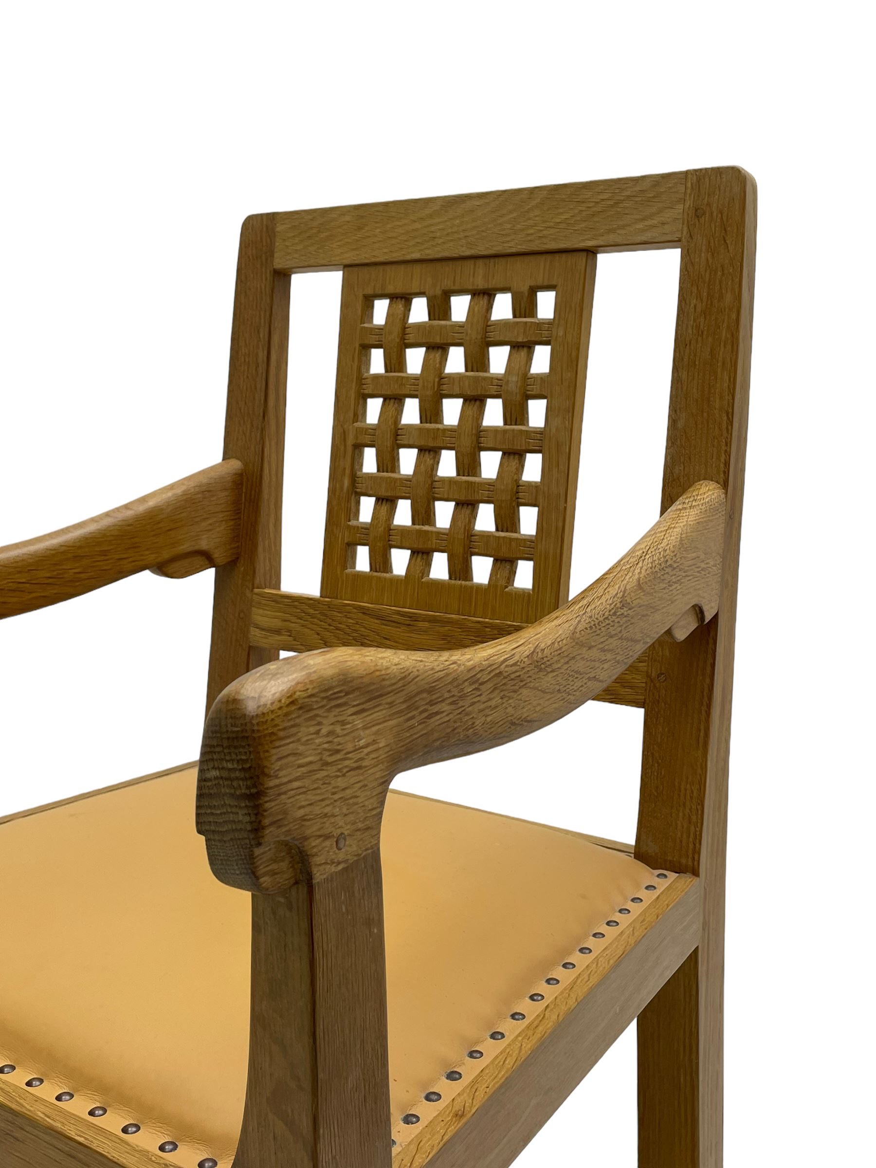 Mouseman - oak carver elbow chair, pierced and carved lattice back over leather upholstered seat with stud band, on octagonal supports united by plain stretchers, carved with mouse signature, by the workshop of Robert Thompson, Kilburn 