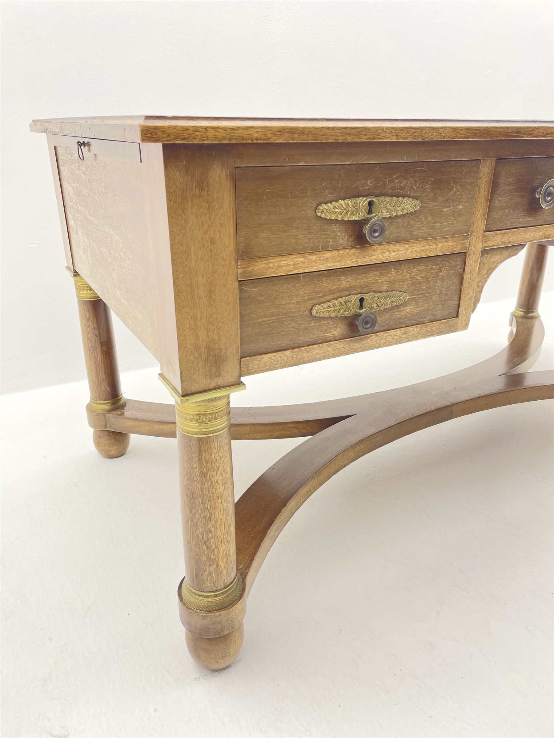 French Empire style walnut desk, moulded rectangular top with inset leather, two leather inset slides either side, fitted with four drawers, turned supports joined by curved x-shaped stretchers, gilt metal mounts 
