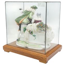 Unterweissbach style porcelain figural group of a seated lady with a gentleman playing a lute, stamped 'Foreign' to base, in bespoke display case