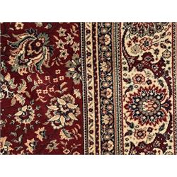 Royal Kashmir worsted wool modern Persian design area rug, with crimson field and stylised rosette patterning throughout, surrounded by wide multi-band border incorporating cartouche and lotus flower motifs