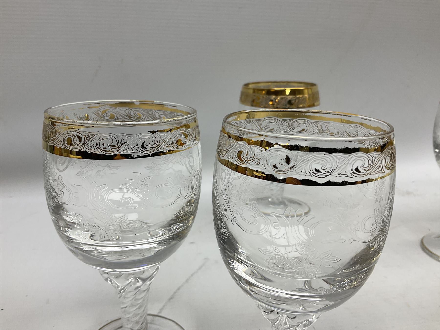Set of twelve Moser style wine glasses, the bowls with etched floral bodies and gold banded rim with foliate decoration raised upon stem of twisted form, H14cm