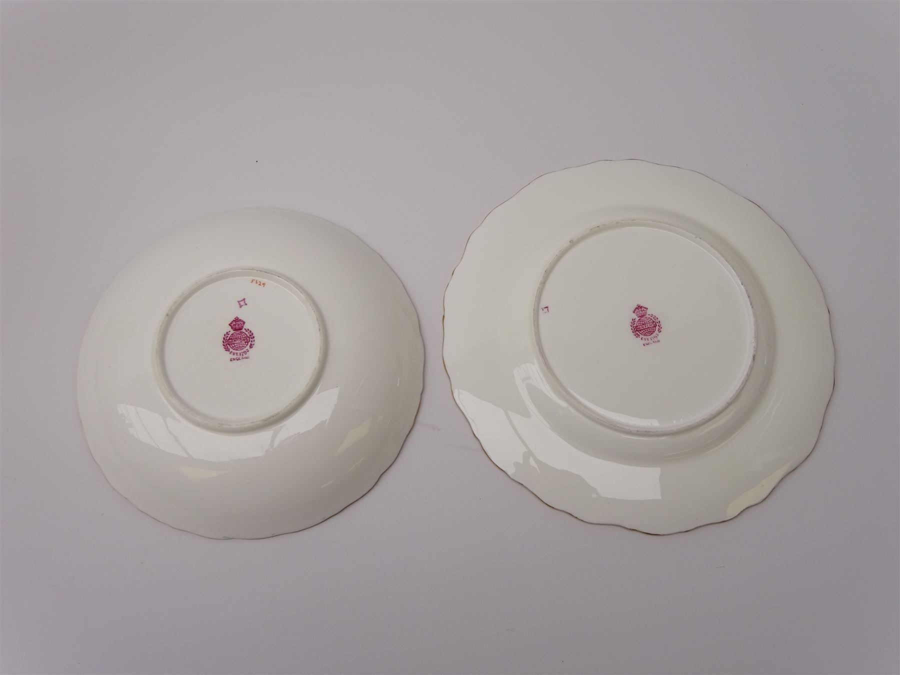 19th century Minton tea set, comprising twelve teacups, eleven saucers, fifteen side plates, cream jug, slop bowl, and two cake plates, decorated with panels of floral sprays, upon a green ground, heightened with gilt throughout, with printed puce mark beneath, and pattern number 5329
