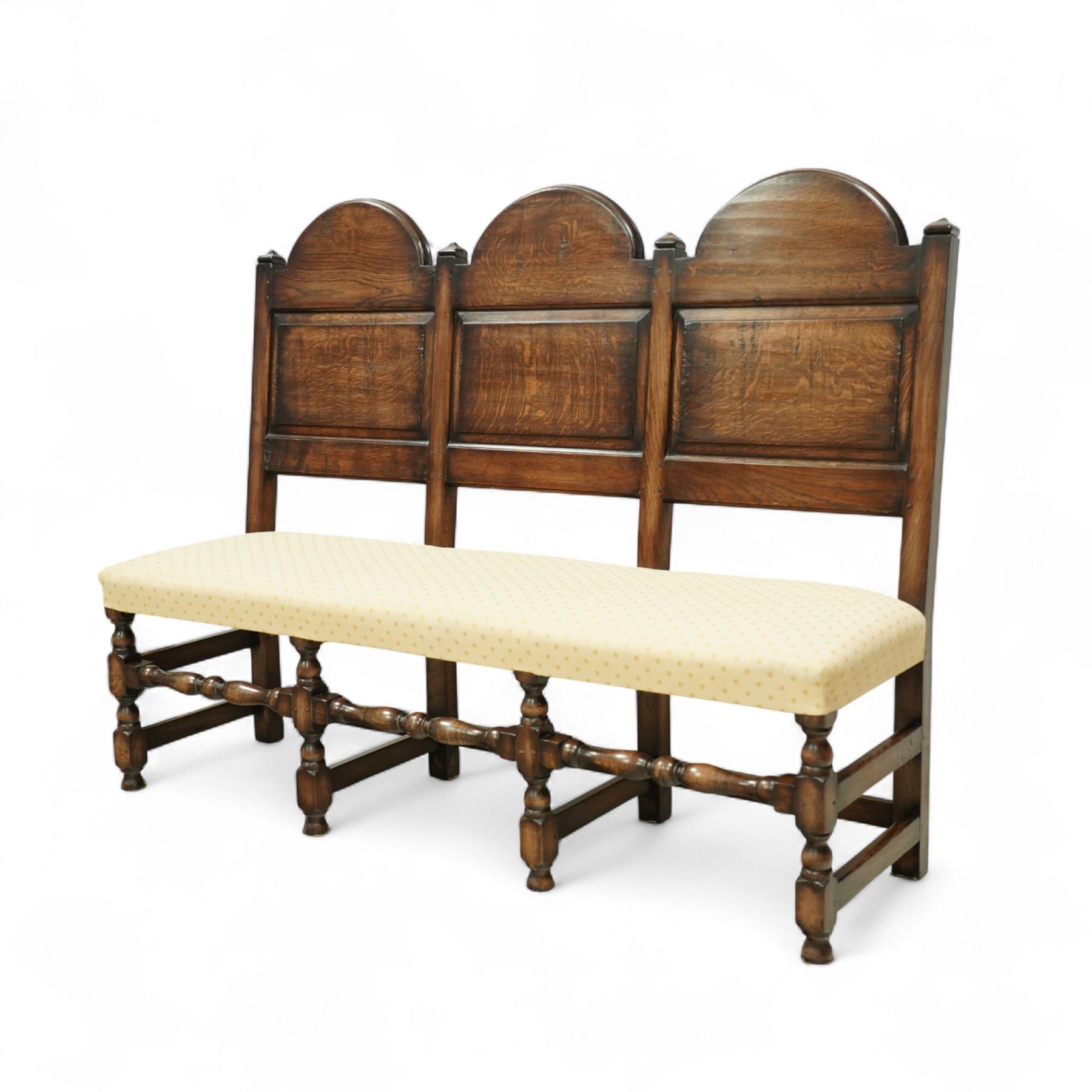 Bylaw of Ross On Wye - 17th-century design oak three-seat hall bench, triple arched panelled back, padded seat upholstered in a yellow herringbone ground fabric with star motif, raised on turned baluster legs united and turned front stretcher