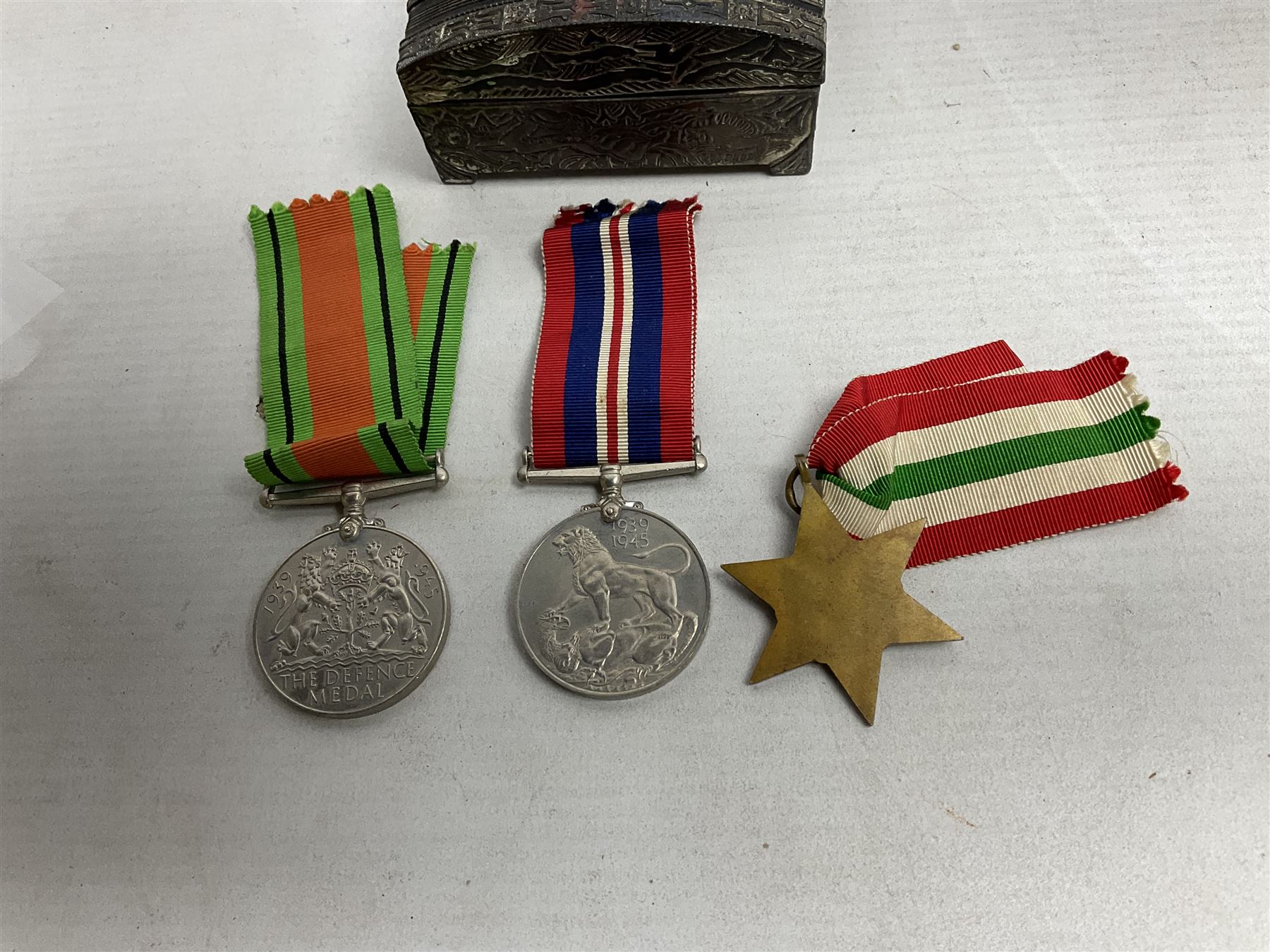 WWII service medal trio comprising Defence Medal, 1939-1945 medal and 1939-1945 Star, with various ribbons and box