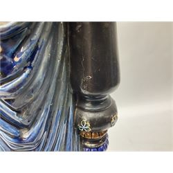 Composite table lamp modelled as a Roman Emperor donning blue robes, upon quatrefoil base modelled with rams heads and winged cherubs, H56cm excl fitting