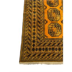Persian Bokhara gold ground rug, three Gul motifs enclosed by multiple patterned border bands