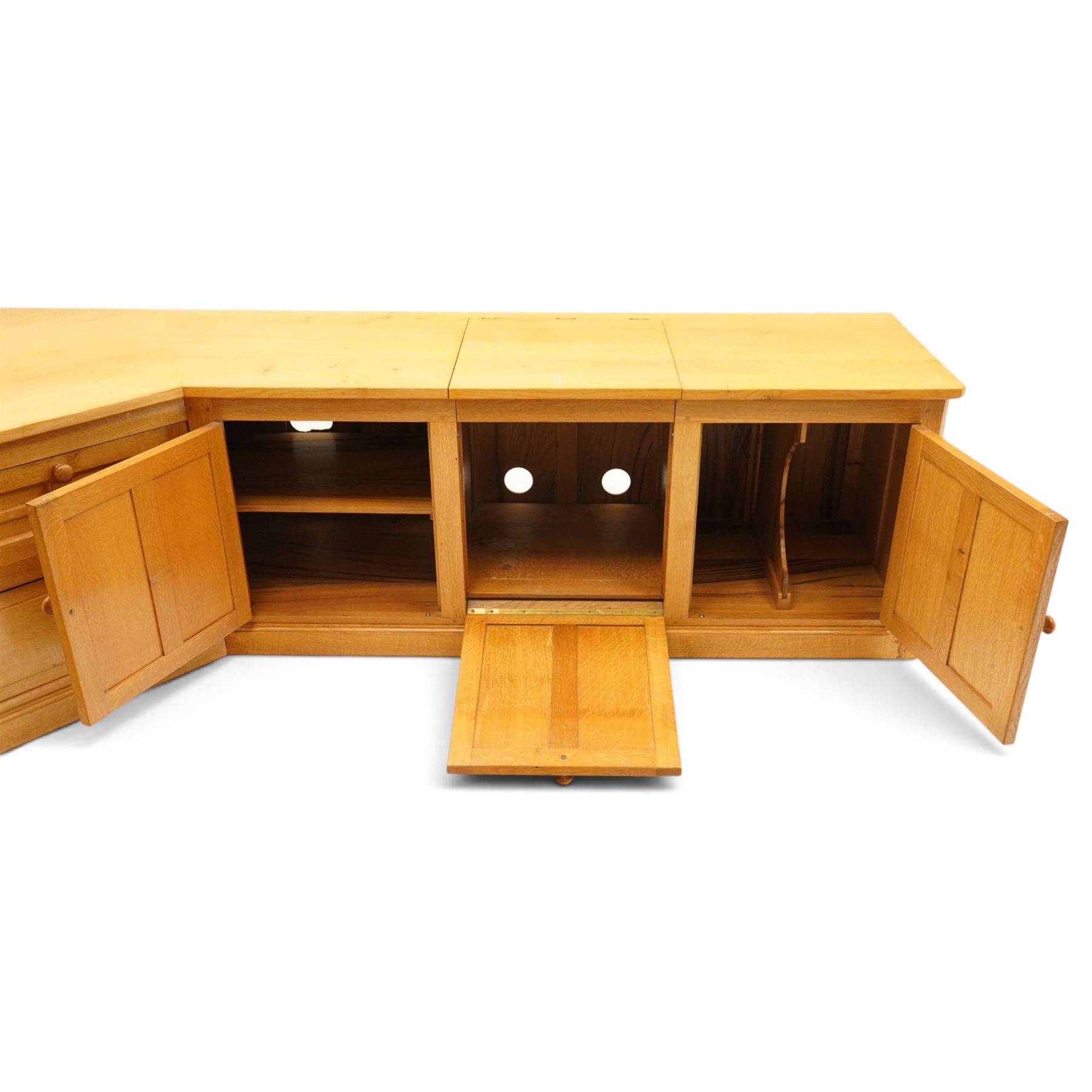 Seahorseman by Shaw & Riley - bespoke large Yorkshire oak corner sideboard or media unit, of L-shape form, with three cupboard doors, a fall front drawer over a regular drawer, a lift up panel for a record player, multiple apertures for wires, raised on a plinth base, with signature Seahorse carving from the workshop of A. Shaw & Riley Ltd, Hessay