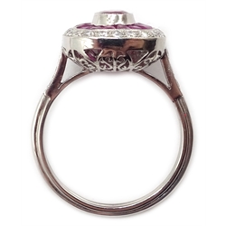  Platinum (tested) ring set with central oval ruby, halo of calibre cut rubies and halo of diamonds, with diamond shoulders  