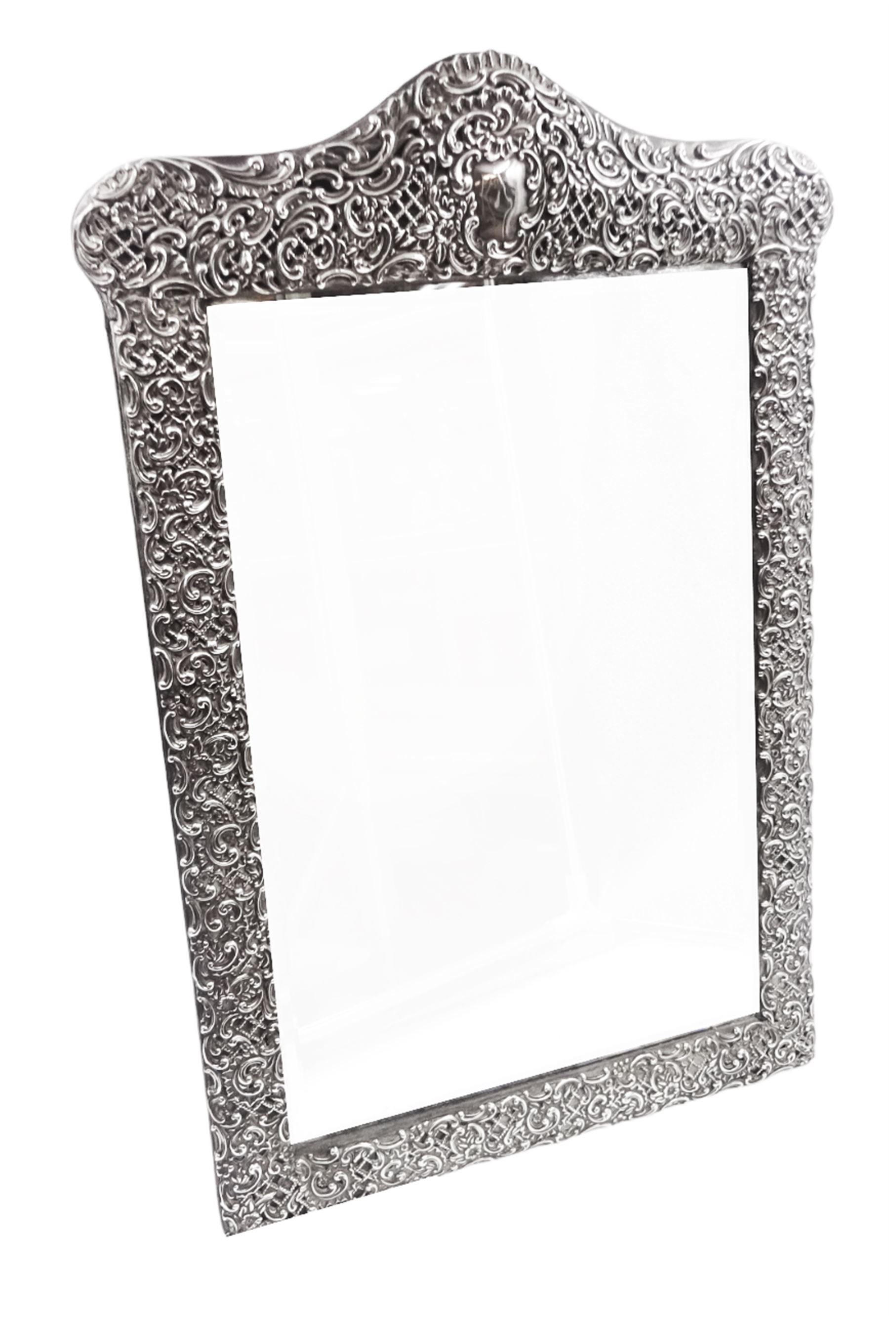 Early 20th century continental silver mounted dressing table top mirror, of rectangular form, the frame embossed with vacant reserve, lattice work, flower heads and C scrolls, with easel style support verso, unmarked but tests as silver, overall H49.5cm W31.5cm