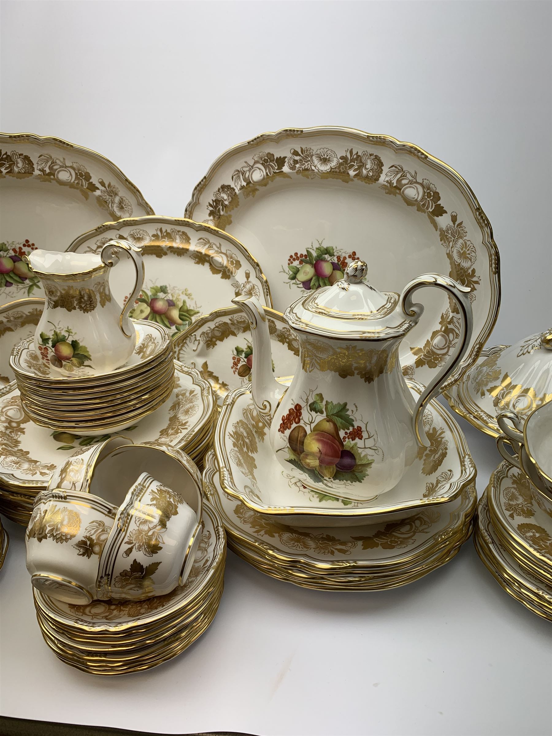 Extensive Spode dinner and tea service, decorated in the Golden Valley pattern, comprising eighteen dinner plates, ten salad plates, ten side plates, ten twin handled soup bowls and ten saucers, ten bowls, two sauce boats and two stands, two square serving dishes, smaller oval serving dish, two tureens and covers, two large oval serving platters, one smaller example, teapot, coffee pot, milk jug, twin handled lidded sucrier, and ten teacups and ten saucers, with red printed marks beneath 