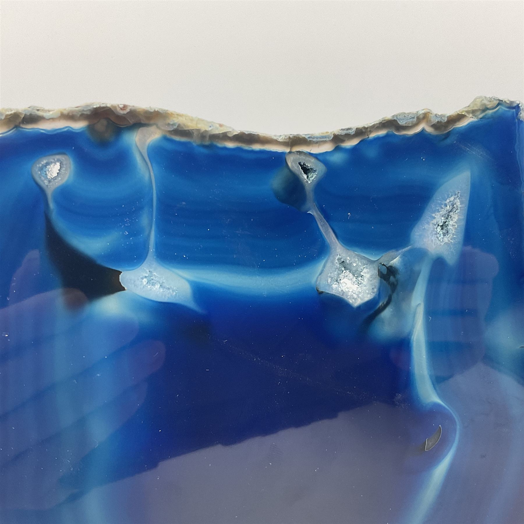 Pair of blue agate slices, polished with rough edges, raised upon silvered metal stands, H26cm