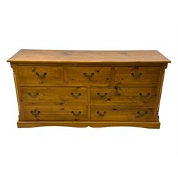 Pine dresser, rectangular top above seven drawers, with two smaller drawers over five larger drawers, all fitted with cast metal handles, raised on a shaped plinth base

