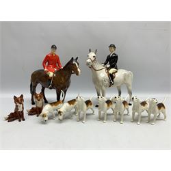 Beswick hunting group, comprising huntswoman on grey horse no 1730, huntsman on brown horse no 1501, two seated fox figures no 1748 and seven fox hounds, all with printed marks beneath (11)
