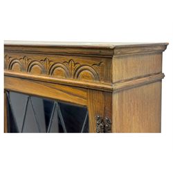Large mid-20th-century oak dresser with two astragal glazed doors between gallery shelf and lower shelf, with three short drawers and lower section with four drawers and three double-panelled linen-fold hinged cupboard doors 