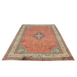 Persian Mahal carpet, red ground field with scrolling interlaced foliate and central medallion, decorated all over with stylised flower and plant motifs, seven band border, the main band ivory ground with scrolling floral design 