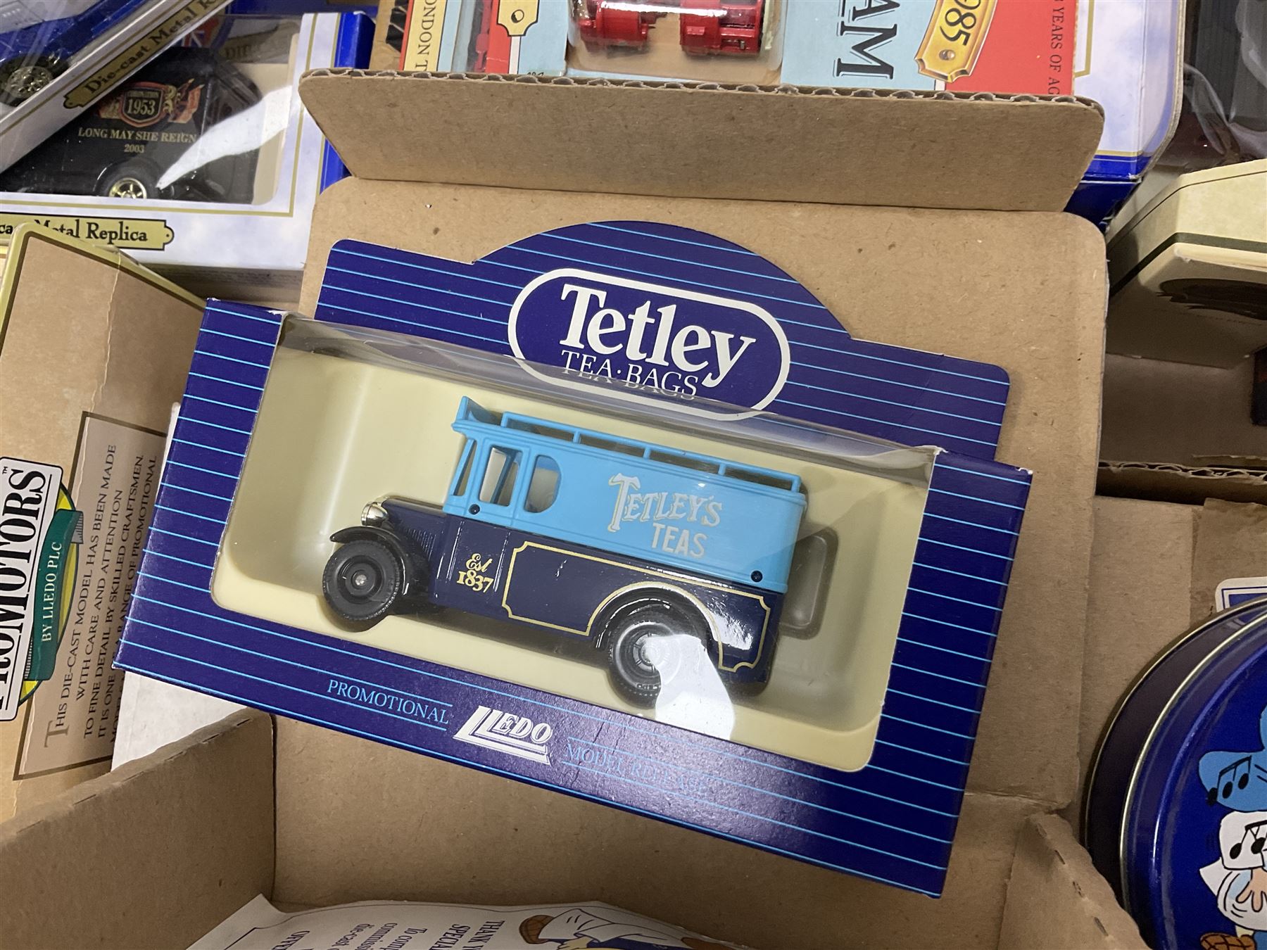 Collection of Tetley Tea collectibles to include sixteen 1:43 scale model cars from Lledo and Oxford Die-Cast with further Tetley Tea figures and tinned coaster set