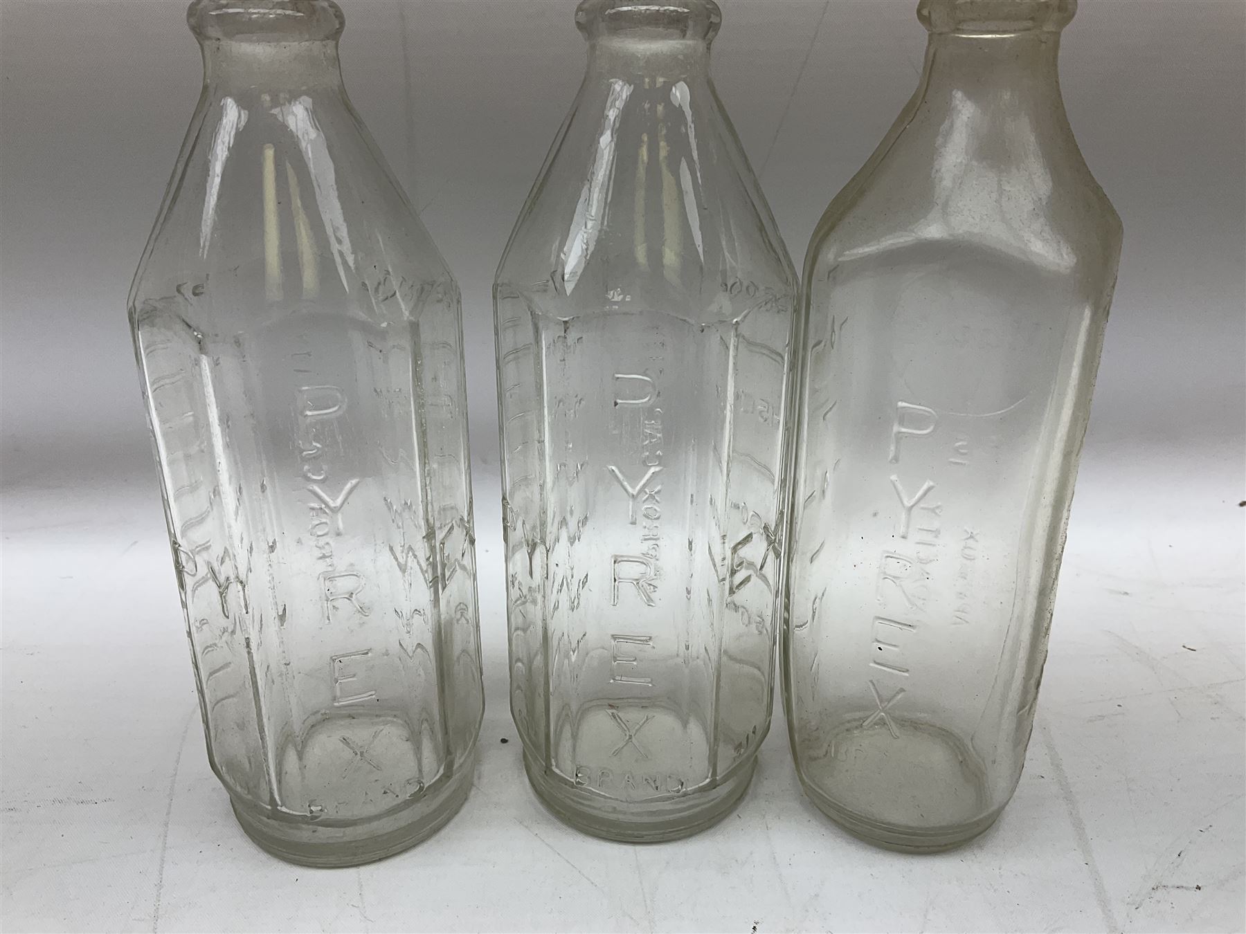 Large stoneware two tone flagon with black lettering Folkard Chemist Pavement York, together with two stoneware jugs, Bronte Yorkshire Liqueur and Creedy Vintage Cider, and salt glaze example, together with four vintage glass bottles, tallest H33cm