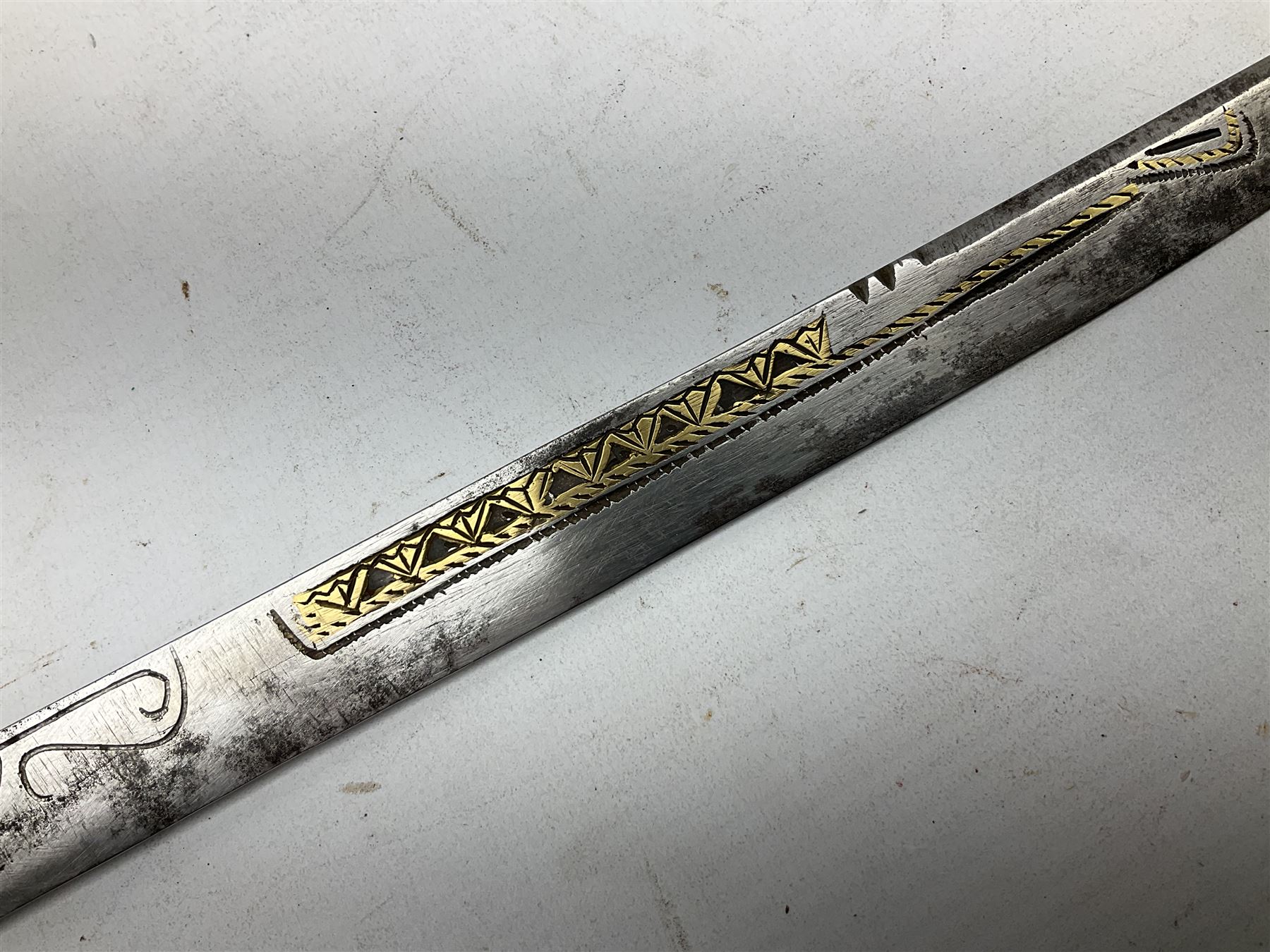 19th century Algerian Flyssa long knife, the 34cm single edged pointed decorative blade inset with yellow metal, chased brass grip with pommel as the snout of a stylised animal and carved hardwood scabbard L45cm overall