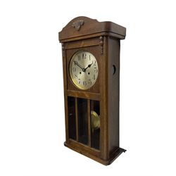A 1930's wall clock in an oak case with a full-length door, three glazed panels and visible pendulum, case with a shaped pediment and applied carving, 6'' silvered dial with Arabic numerals, minute track and steel baton hands, eight day going barrel movement striking the hours on a gong.

	



