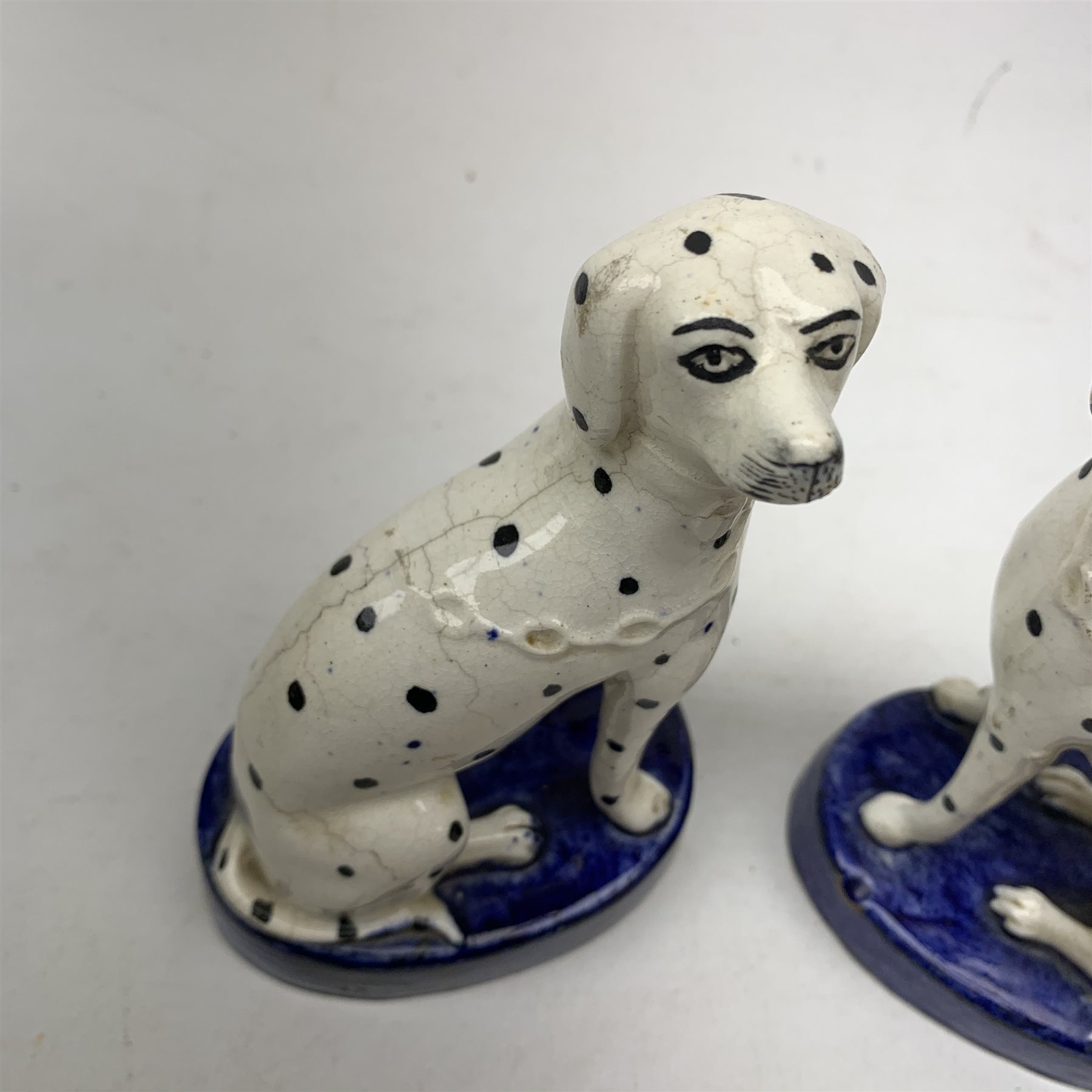 A large 19th century Staffordshire loving cup, detailed 'The Real Cabinet of Friendship Justice and Equity' (a/f), H22cm, together with a pair of 19th century Staffordshire dalmatians, upon oval blue bases, H13cm, a Dresden ewer hand painted with floral sprays, with mark beneath, H15.5cm, and a Coalbrookdale style floral encrusted vase and cover, H16.5cm. 