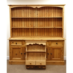  Solid pine dresser, projecting cornice, two tier plate rack, four drawers above four cupboards, plinth base (W182cm, H192cm, D48cm) and a wall hanging unit, single shelf, two drawers (W64cm, H82cm, D20cm) (2)  