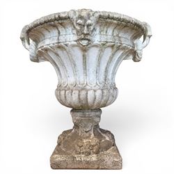 Pair of Neoclassical design cast stone garden urns, each of campana form with fluted body and gadrooned underbelly, decorated with faun/satyr opposing masks and ropetwist handles, with floral and mask design to the socles, raised on square bases, finished in weathered white patina