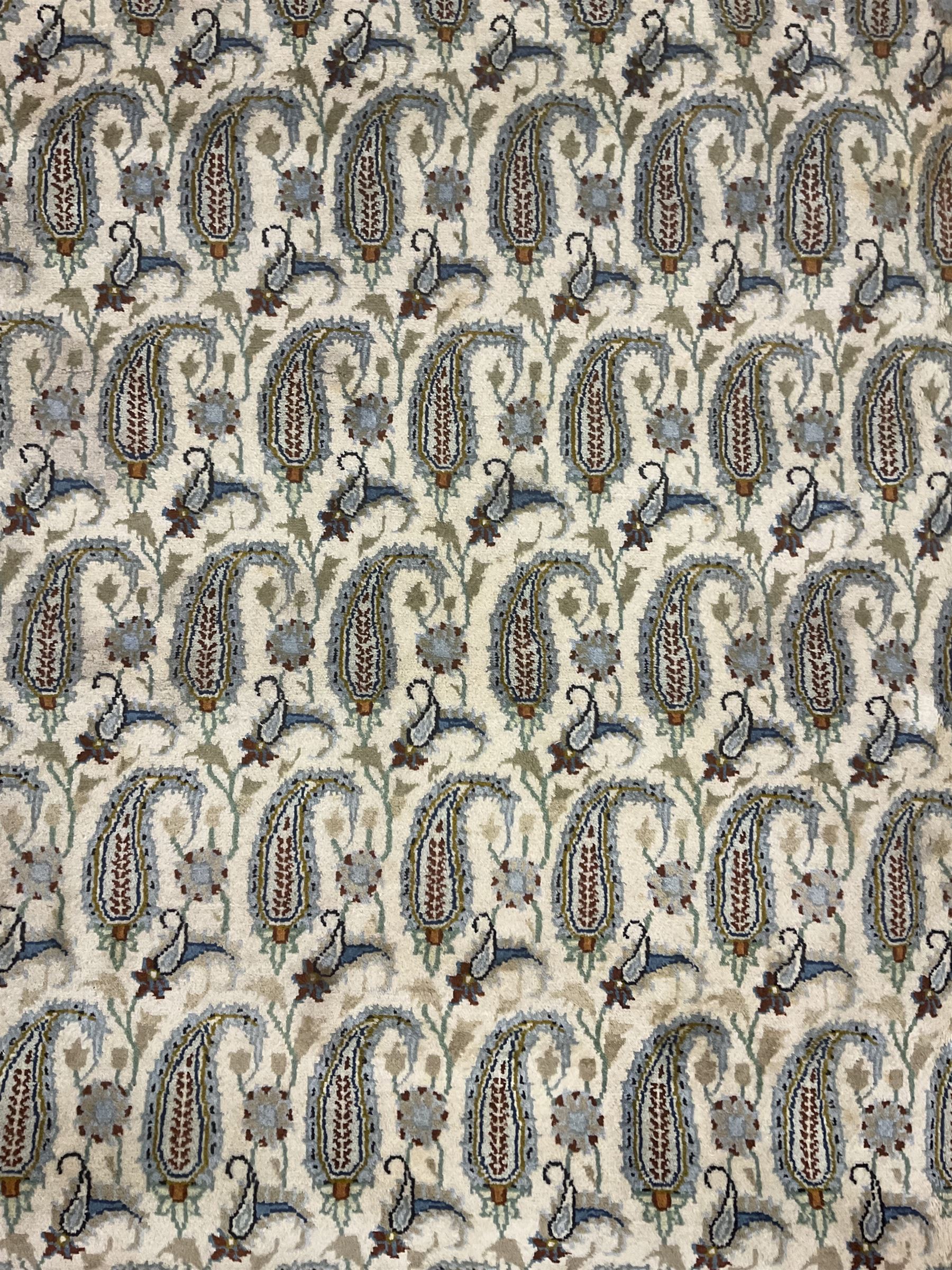 Central Persian Kashan ivory ground carpet, decorated with repeating Boteh motifs, the three band border decorated with further Boteh motifs