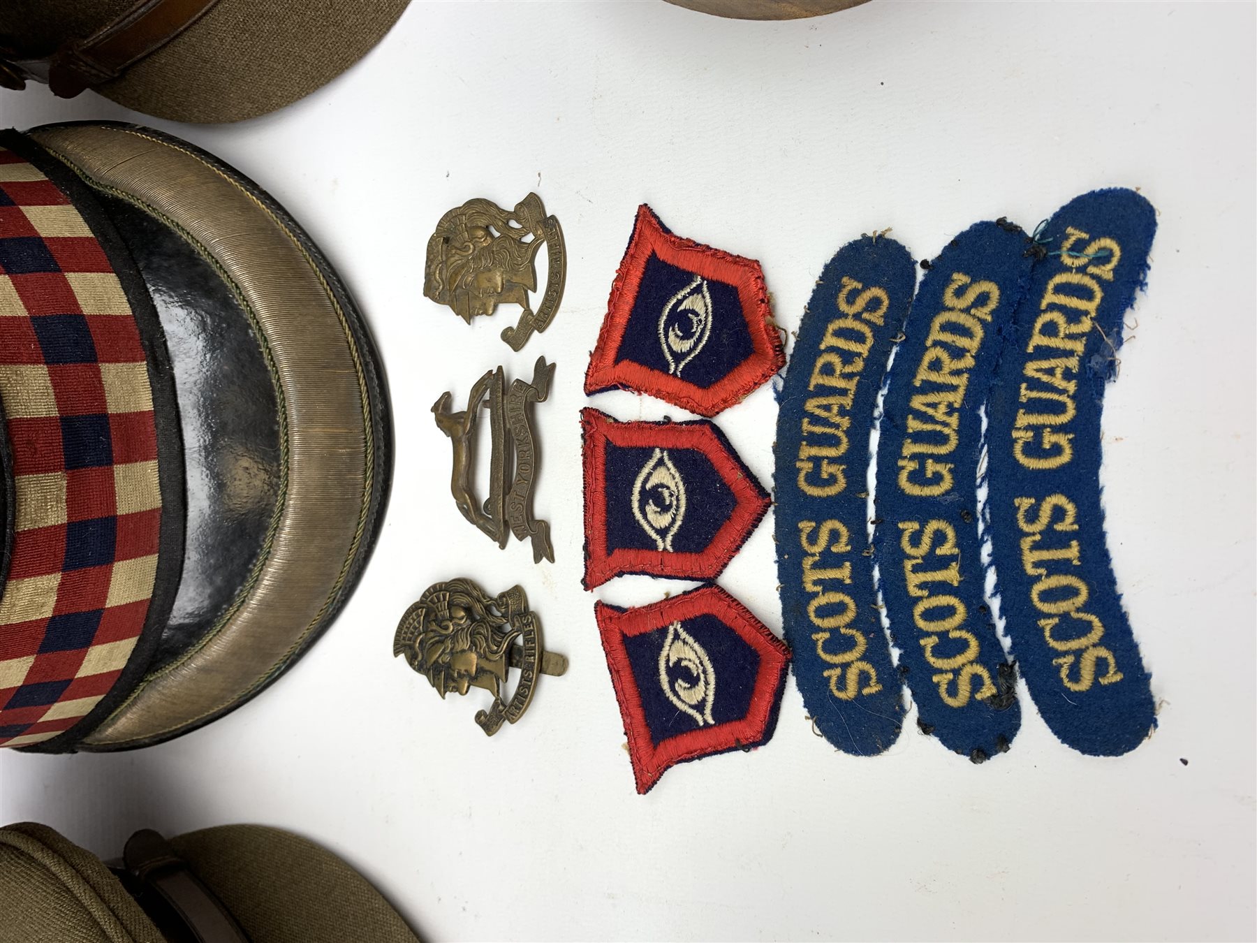 Scots Guards - two officer's peaked caps with chin strap and side buttons, one with badge, and blue dress peaked cap marked HEB for Harold Ellett-Brown; two Artist Rifles and one West Yorkshire cap badges and two Scots Guards shoulder flashes; officer's brown leather Sam Brown belt with shoulder brace strap and revolver holster; officer's Orilux trench torch etc