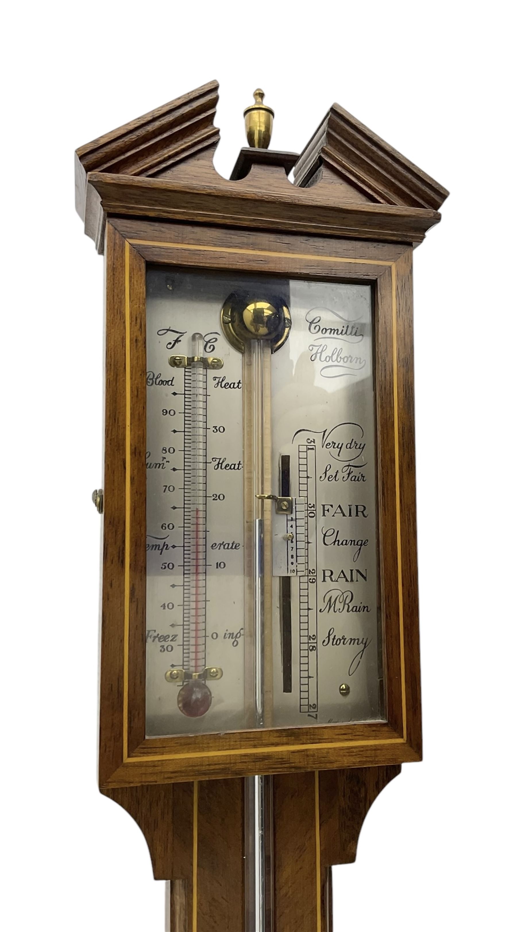 Comitti-20th century mercury stick barometer in an 18th century style mahogany case with satinwood stringing, with a broken pediment, brass finial and round base, silvered register with recording vernier, weather predictions and a centigrade/Fahrenheit spirit thermometer enclosed within a glazed door, visible tube with a bulb cistern and turned mahogany cover.
Mercury clean and present with no air locks.