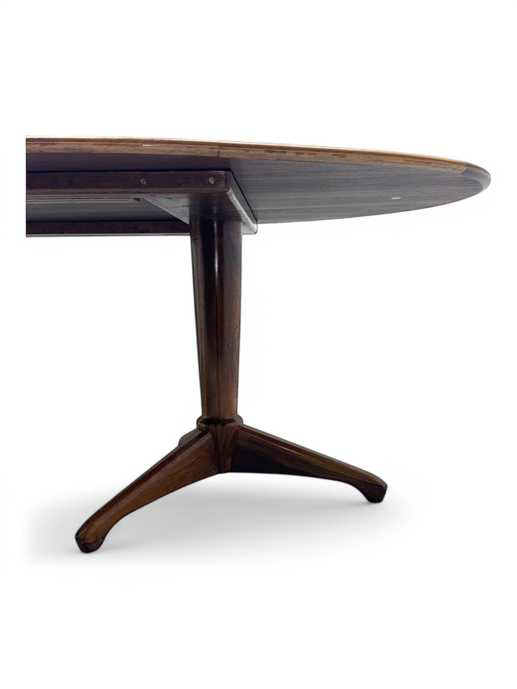 Andrew Milne for Heals - mid-20th century extending dining or boardroom table, oval top with one additional leaf, raised on twin tapering pedestal supports terminating in tripod feet
