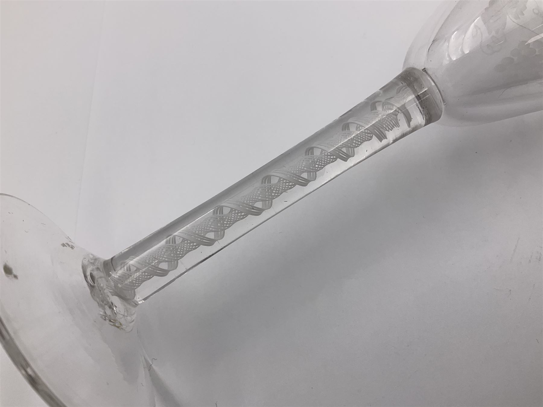 Set of three 18th century style wine glasses, each with funnel bowl etched with fruit vine, upon a double series air twist stem and circular foot, H17cm