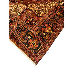Persian Heriz golden red ground carpet, large floral medallion on field decorated with interlaced foliate, the border decorated with plant motifs 