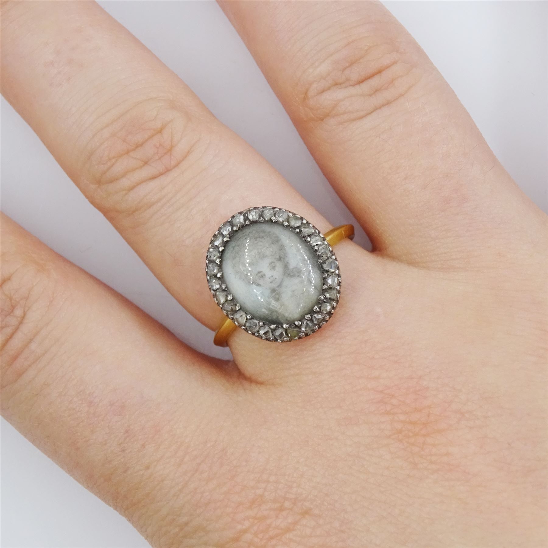 18th / 19th century gold and silver diamond portrait ring, set with an oval miniature of a woman on ivory, under glazed panel, with rose cut diamond surround and angular shank. This lot has been registered for sale under Section 10 of the APHA Ivory Act