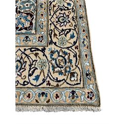 Persian Kashan ivory ground rug, central medallion surrounded by scrolling leafy branches and stylised flowerhead motifs, scrolling border decorated with further stylised plant motifs
