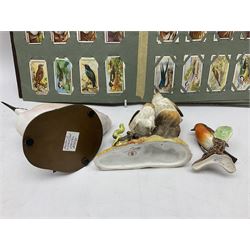 Three ceramic bird figures comprising Royal Crown Derby thrush chicks, Albany Royal Worcester crested grebe and a Goebel robin, along with 'British Birds' and 'Birds Eggs' Ogden's cigarette cards housed in an album
