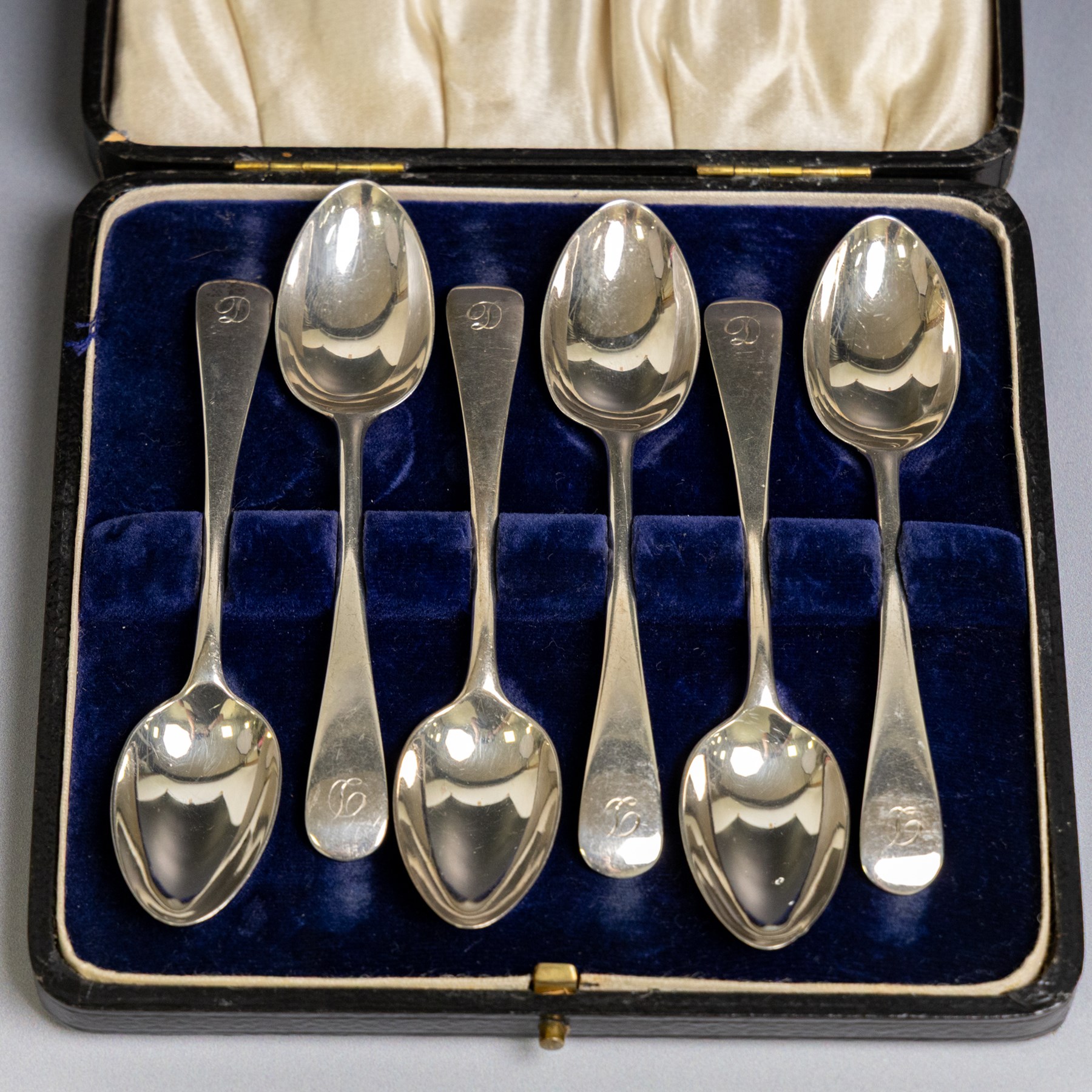 Set of six 1920s silver teaspoons with engraved initials, together with two sets of silver handled tea and fruit knives, all hallmarked and all within fitted cases
