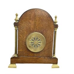 French - Early 20th century oak cased 8-day striking mantle clock, with an arched top, finials and applied brass casting depicting putti to the tympanum, with reeded brass columns to the corners and raised on splayed brass feet, gilt metal dial with enamel cartouche Arabic numerals and pierced steel hands, rack striking movement striking the hours and half hours on a coiled gong. With pendulum and key.  